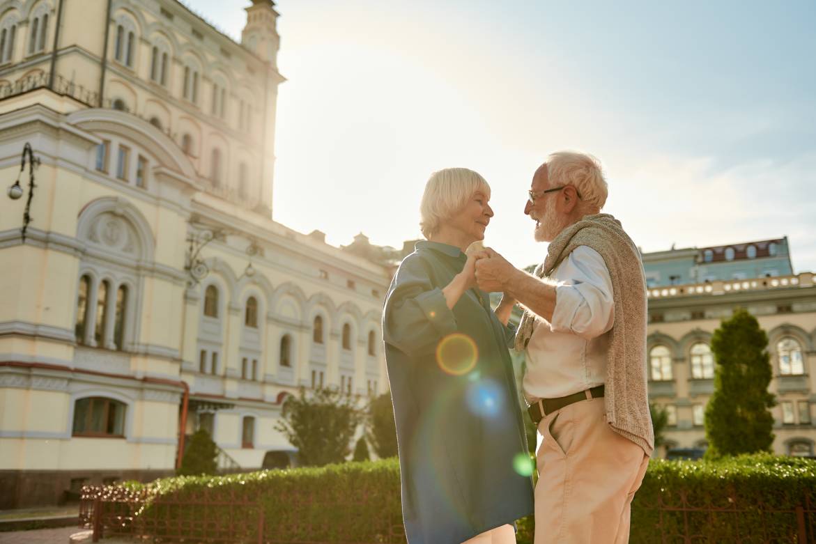 Beautiful and happy senior couple dancing together outdoors on a sunny day