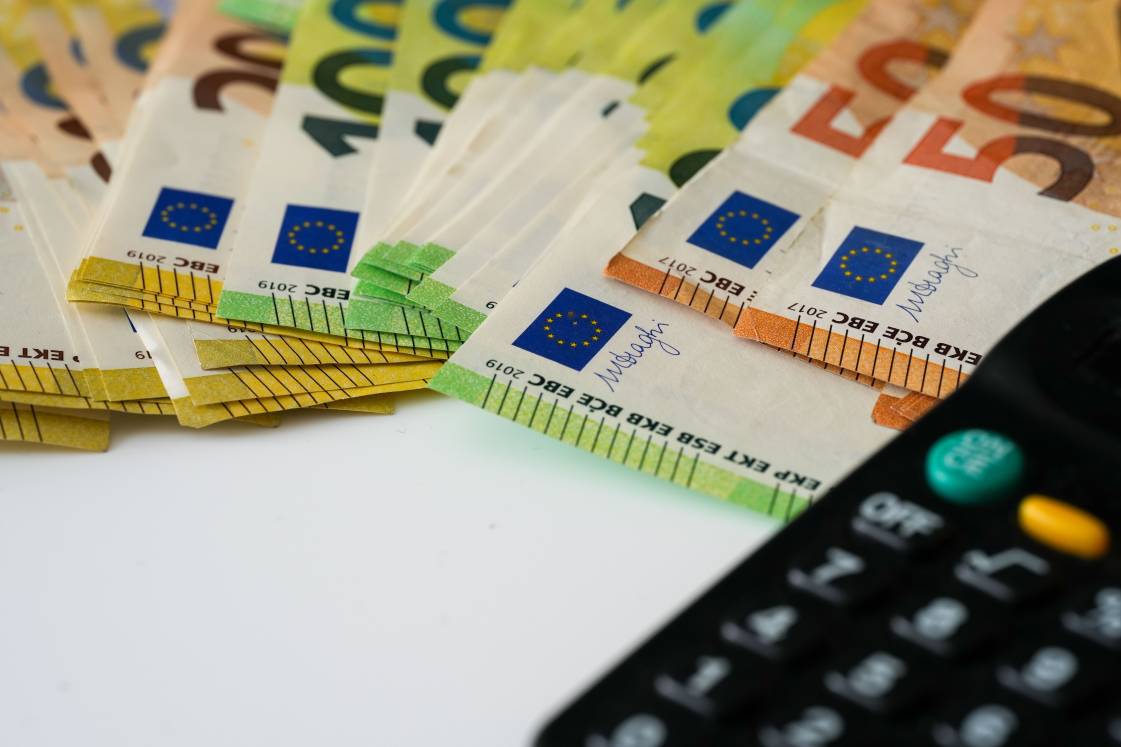 Euro banknotes with the black calculator on white background, close-up