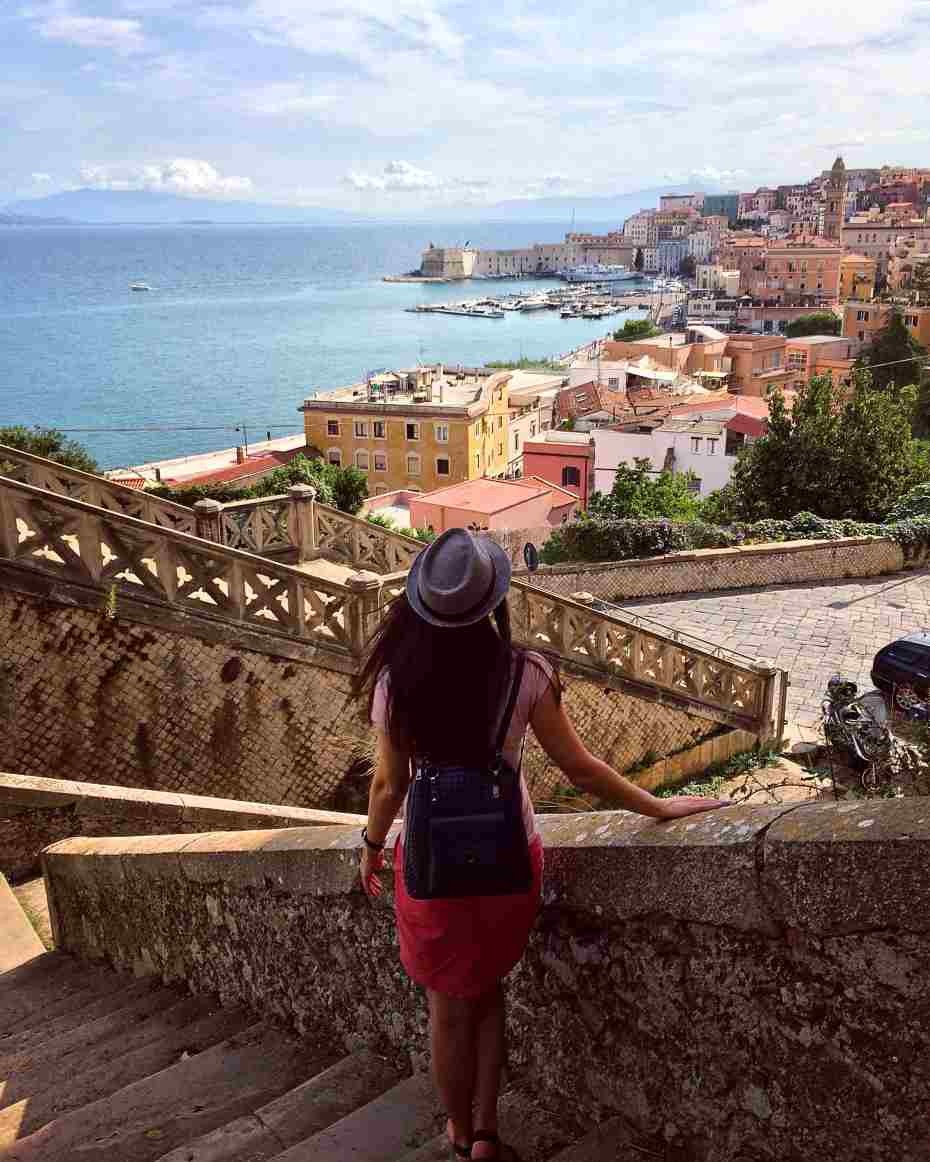 Girl looks at the beautiful seascape and the old town in the Italian city of Gaeta