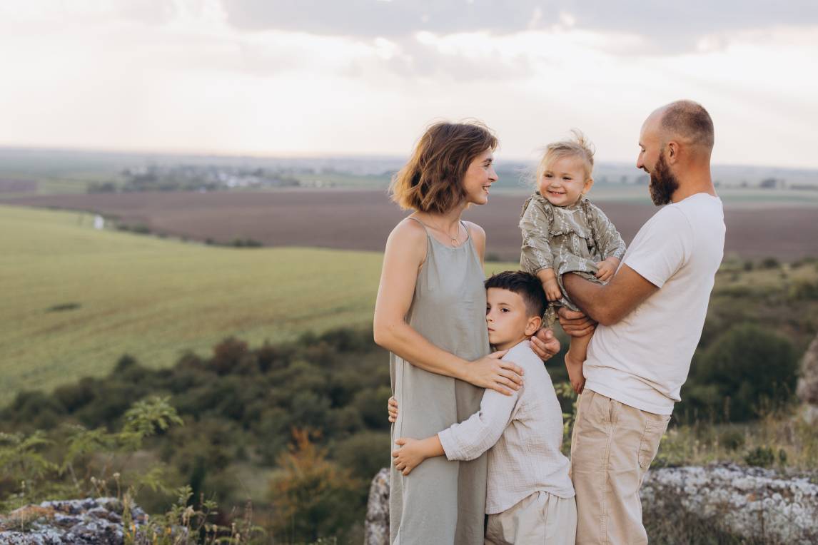 Happy Family Enjoying Time Together in a Scenic Countryside Landscape on a Beautiful Day