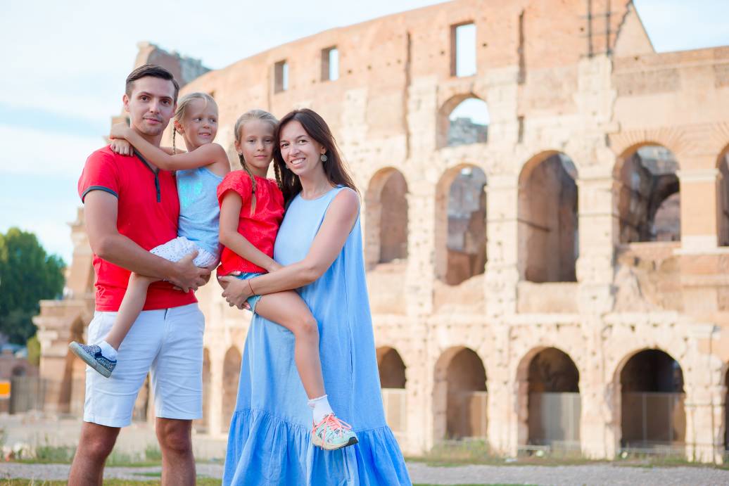 Happy family in Rome over Coliseum background. Italian european vacation together