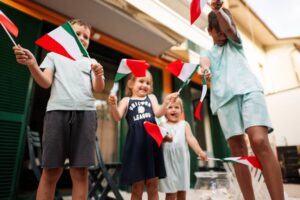 Happy four kids with italian flags celebrating Republic Day of Italy