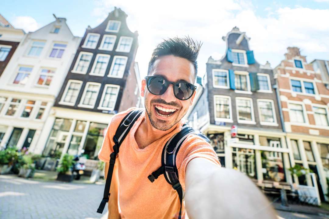 Happy tourist taking selfie picture in Amsterdam, Netherlands