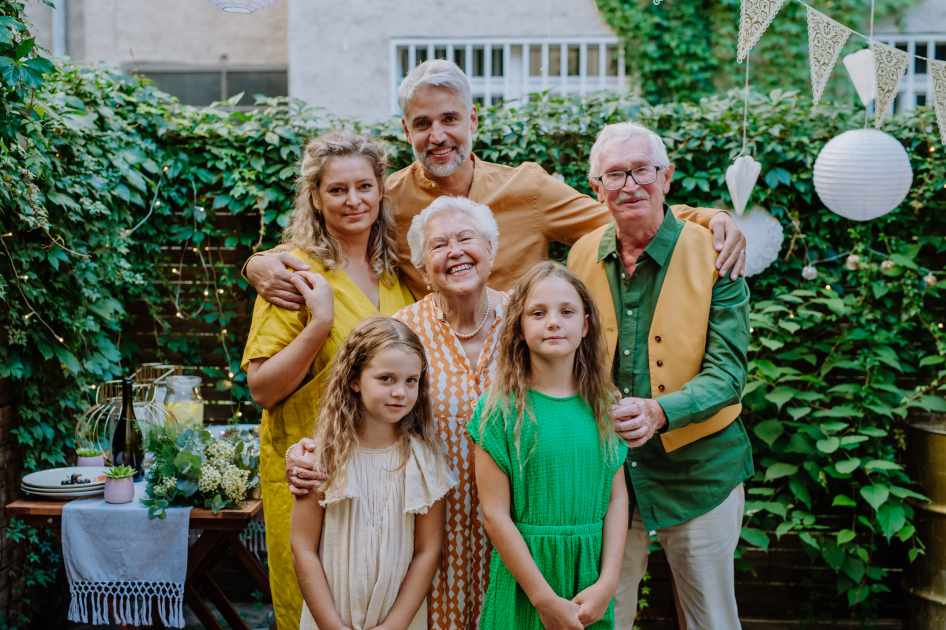 Multi-generation family on outdoor summer garden party, celebrating birthday