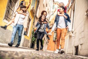 Multicultural friends group piggybacking and enjoy time together in the city
