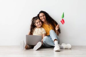 Portrait Of Arab Mother And Little Daughter With Laptop And Italian Flag