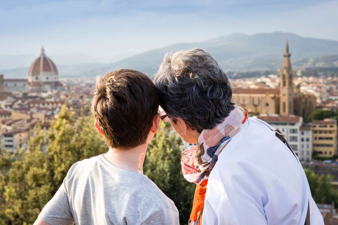 Senior woman and grandson looking out at cityscape, Florence, Italy