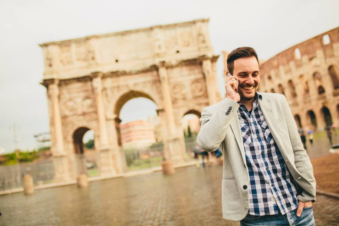 Young man with mobile phone on the street in Rome, Italy