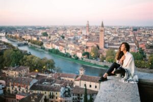 Young woman enjoying beautiful view on Verona city in Italy in the morning