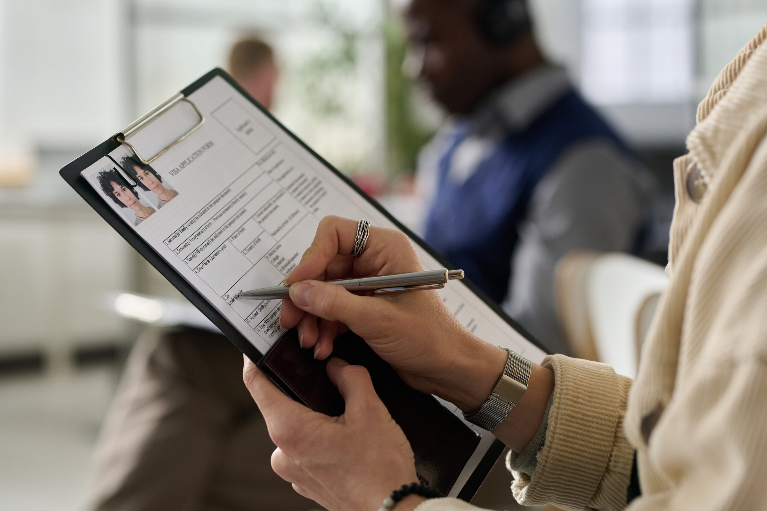 Applicant completing Visa application paperwork with supporting documents